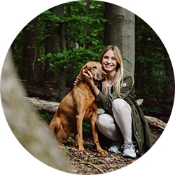 Katharina Miklauz im Wald mit ihrem Hund Pluto