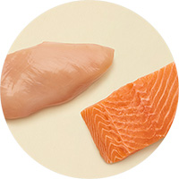 Rohes Huhn und roher Lachs auf Beigen Hintergrund